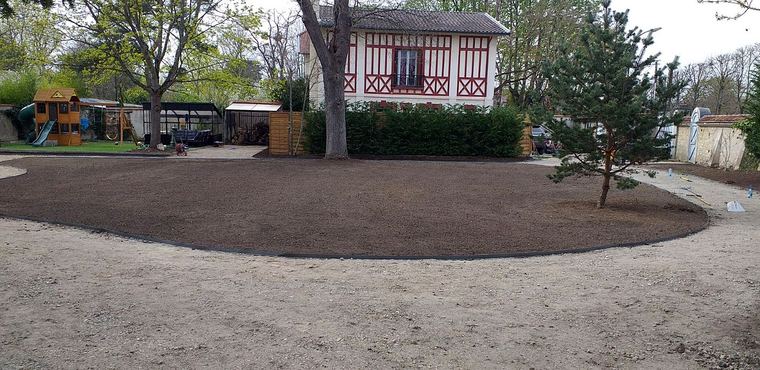 Jardin en création : allée courbe tracée autour d’un massif de terre prête à semer